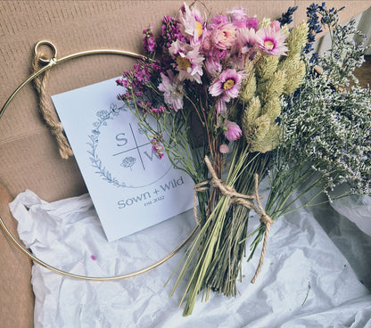 Dried flowers pictured in a box with hoops and a leaflet for DIY wreath kit