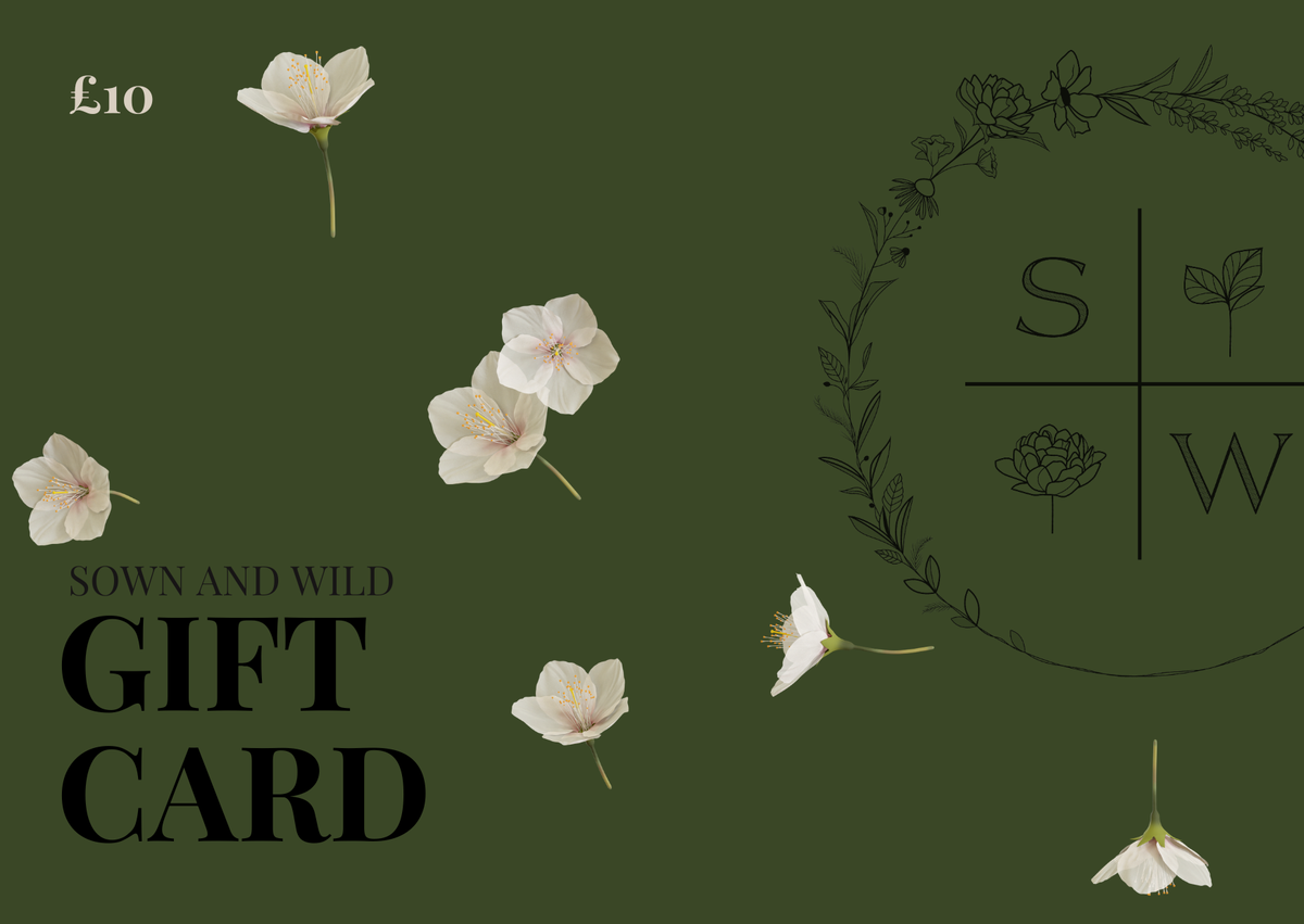 A dark olive green gift card design with scattered white flowers, the text '£10' in the top left, 'SOWN AND WILD GIFT CARD' on the left, and a floral wreath monogram with 'S' and 'W' on the right.