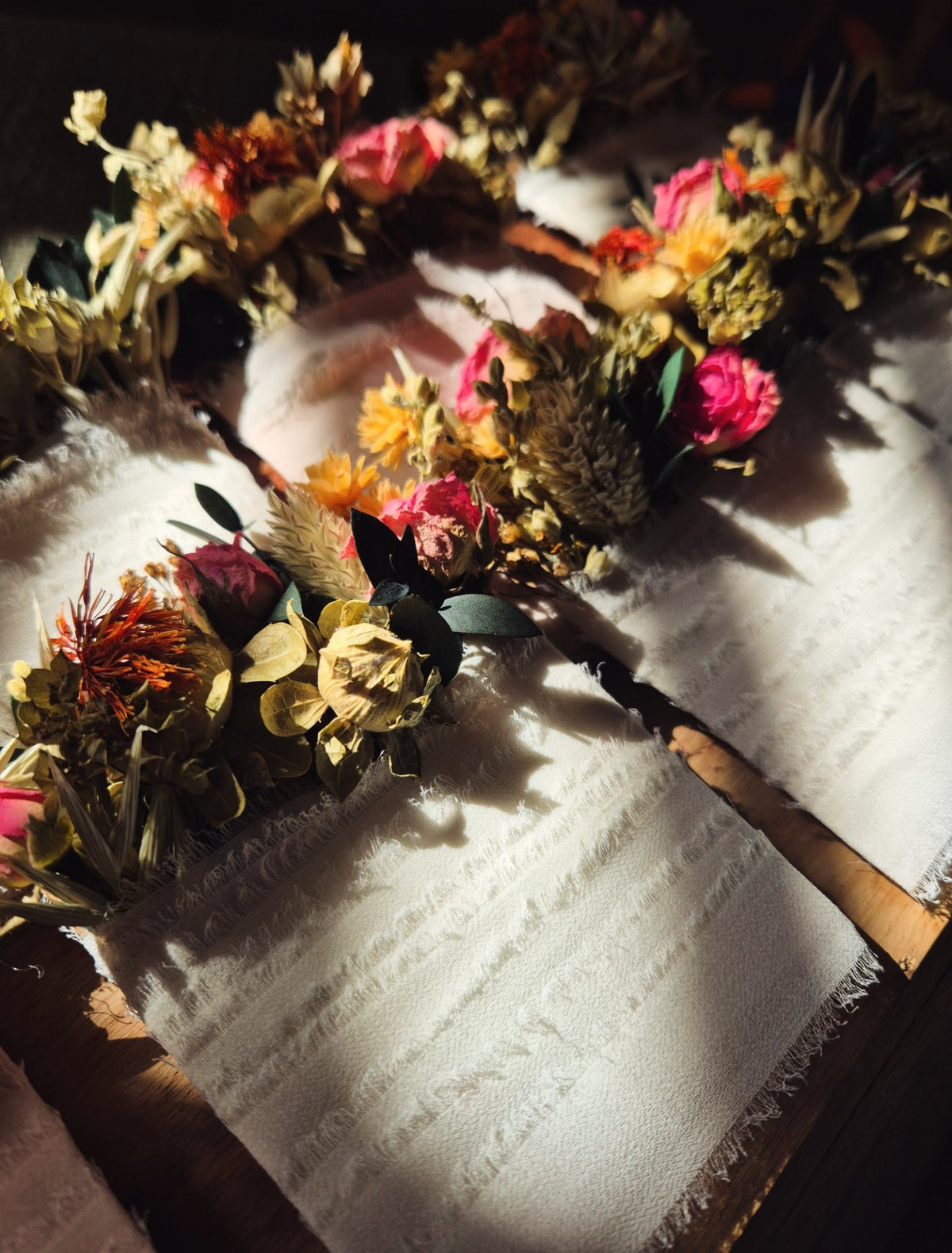 Soft lighting featuring 2 rows of dried flower grooms and groomsmen pocket squares.