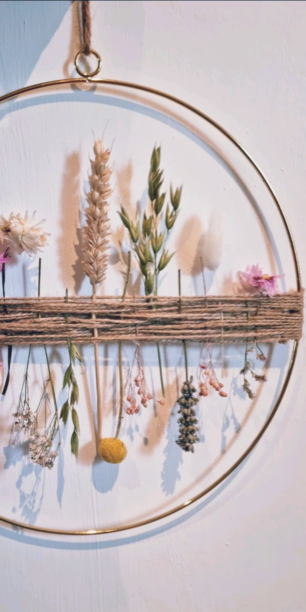 A spring inspired dried flower hoop pictured on a white background